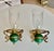 Pair of Italian brass faux oil lamp wall sconces, with green colored glass bodies and glass hurricane shades. Each sconce...