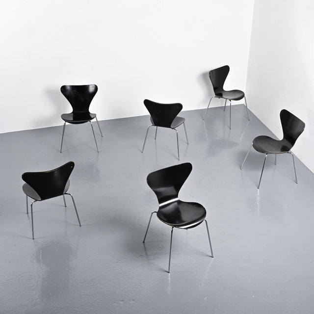 Set of model 3107 "Series 7" chairs designed by Arne Jacobsen in 1955. Made of molded, black lacquered plywood resting on...