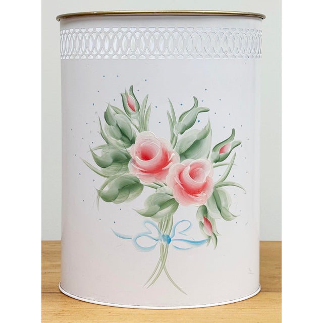 Vintage tole-painted metal wastebasket with a pale pink rose display. Top rim features a lace-like reticulated cut-out...