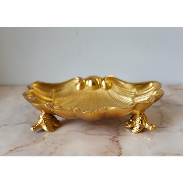 Add a touch of whimsical coastal elegance to your home with this vintage gold-toned bronze shell catchall dish. Featuring...