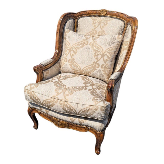 This is a stunning French Provincial, Louis XV–style wingback bergère chair with a hand-carved walnut frame finished with...