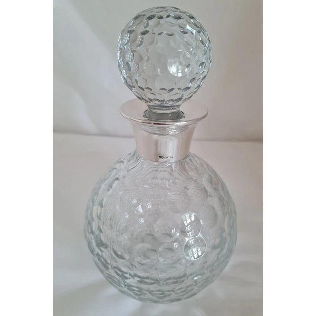 A distinctive vintage British spirit decanter by Camelot Silverware Ltd, dating to 1991 and combining finely cut glass...