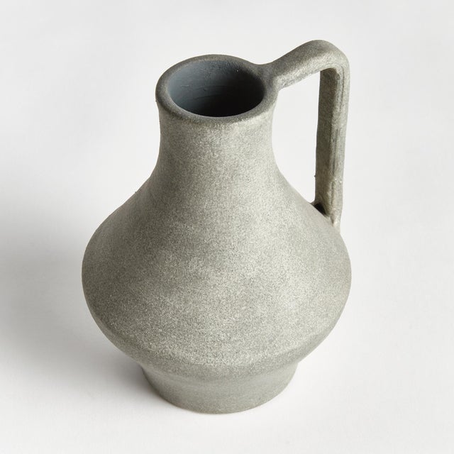 Made in an amphora style, this decorative vase is made to look like a mediterraneaninspired water jug. With a cold finish,...
