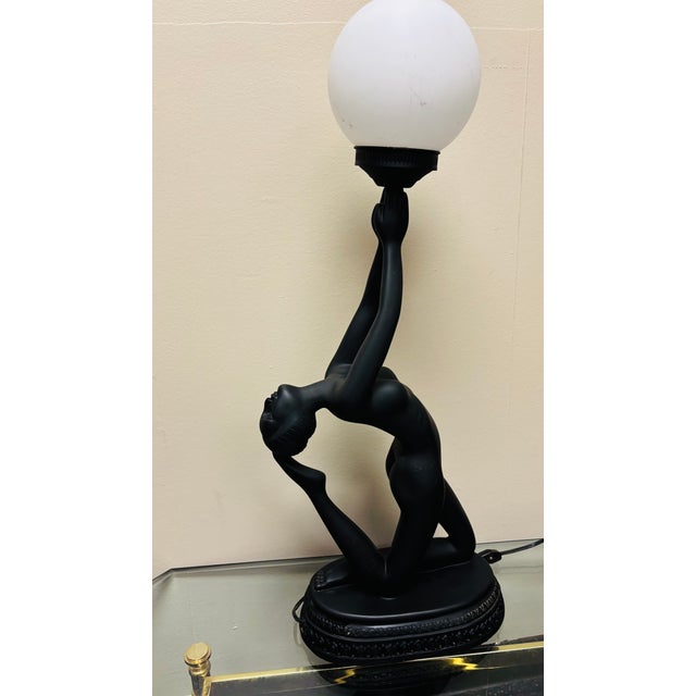 Description Bring timeless sophistication to any interior with this striking Art Deco style figural table lamp. Featuring...