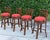 A set of four Tommy Bahama Island Estate faux-bamboo swivel barstools featuring sculptural frames in a rich plantation...
