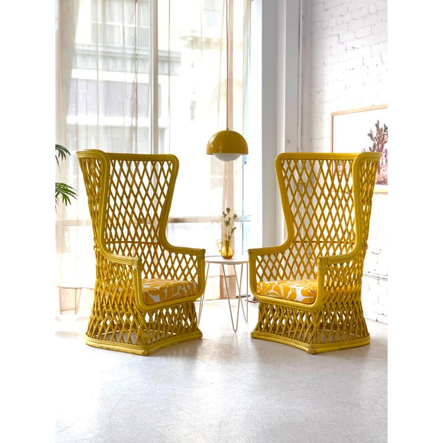 Rare matched pair of vintage 1970s high-back rattan wingback chairs featuring dramatic sculptural silhouettes and open...