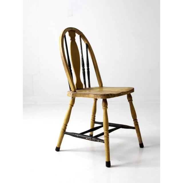 An antique painted Windsor style chair featuring a classic splat back and beautifully turned spindles. The traditional...