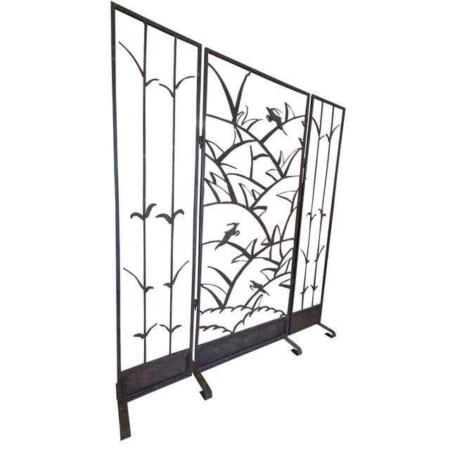 A striking and highly sculptural three-panel folding screen executed in hand-forged iron, showcasing an expressive...