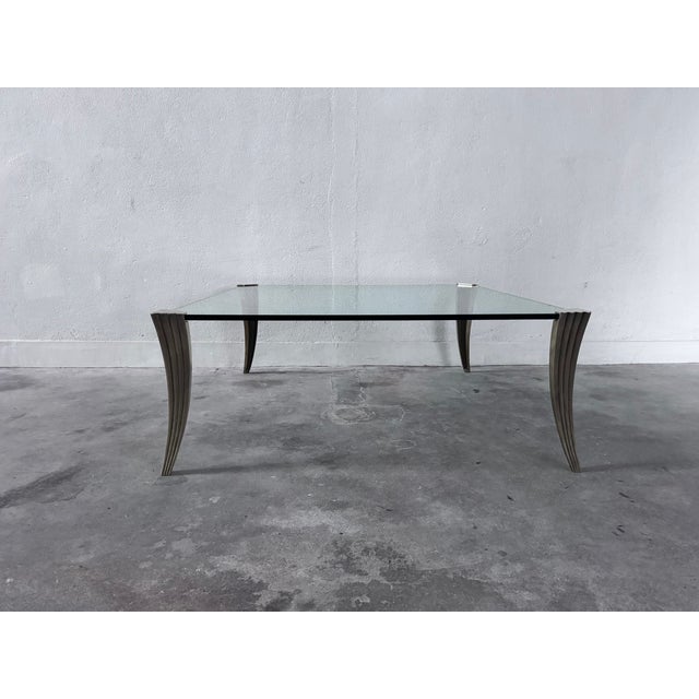 1970s coffee table with a heavy clear glass tabletop and solid brass legs. The table is in excellent condition. The...