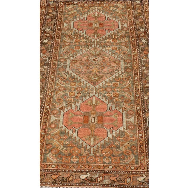 This antique hamadan features three medallions in the field, surrounded by sub-geometric tribal motifs. The complementary...