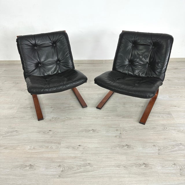 Dimensions: H 30” x W 24.5” x D 28” x SH 17.5” Pair of Vintage Scandinavian teak Kengu-chairs in black leather designed by...