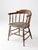 This late 19th-century captain's chair features a classic spindle-back form with a shaped crest rail, turned supports, and...