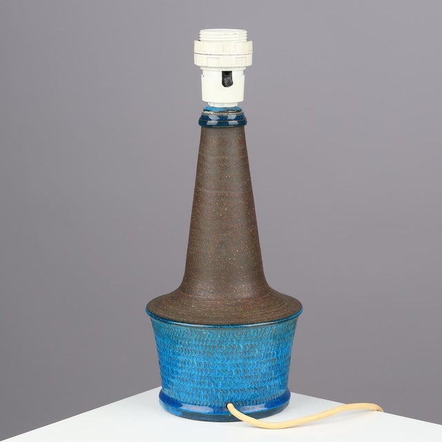 Table lamp made of partly blue-glazed stoneware with relief pattern. Signed “HAK Nils” and stamped “Made in Denmark” on...