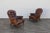 A handsome pair of vintage 1980s brown leather library armchairs, featuring beautifully distressed leather with a rich,...