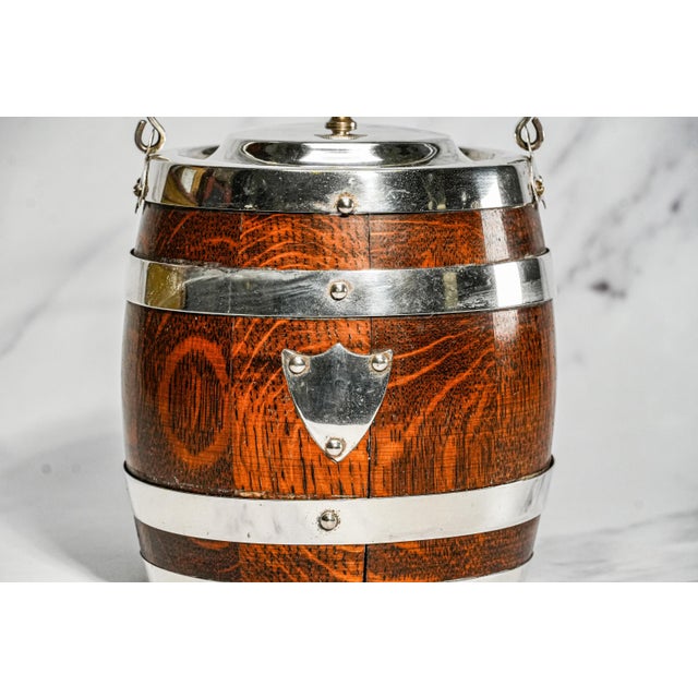 Offered here is a delightful English antique biscuit barrel, beautifully crafted with an oak wood exterior and a porcelain...