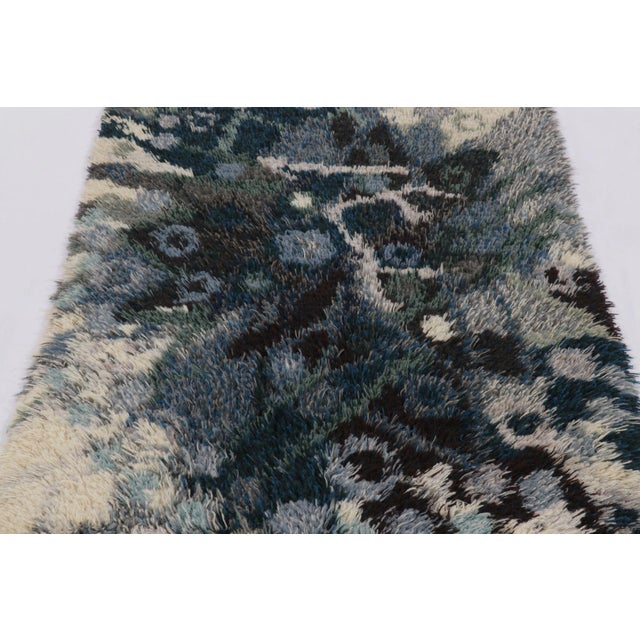 Hand-knotted in lush, high-pile wool in Sweden circa 1960-1970, this 4x6 vintage Swedish Rya rug is a bold new addition to...