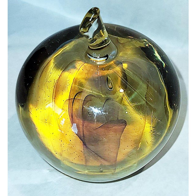 Cloudlike hologram filled amber glass apple paper weight signed Gilbert, c. 1970s.
