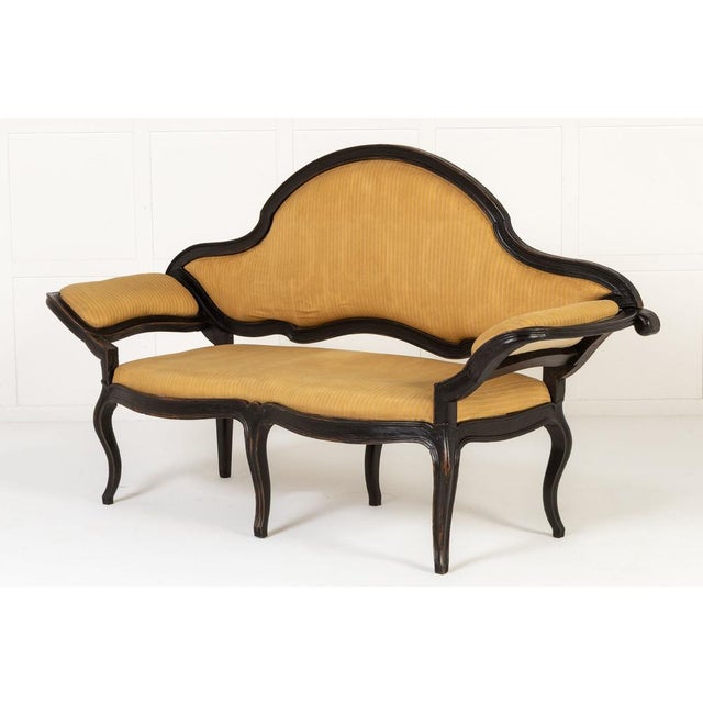 A 18th century italian ebonised sofa. in the rococo style, this ebonised sofa is curvaceous and serpentine in form. The...
