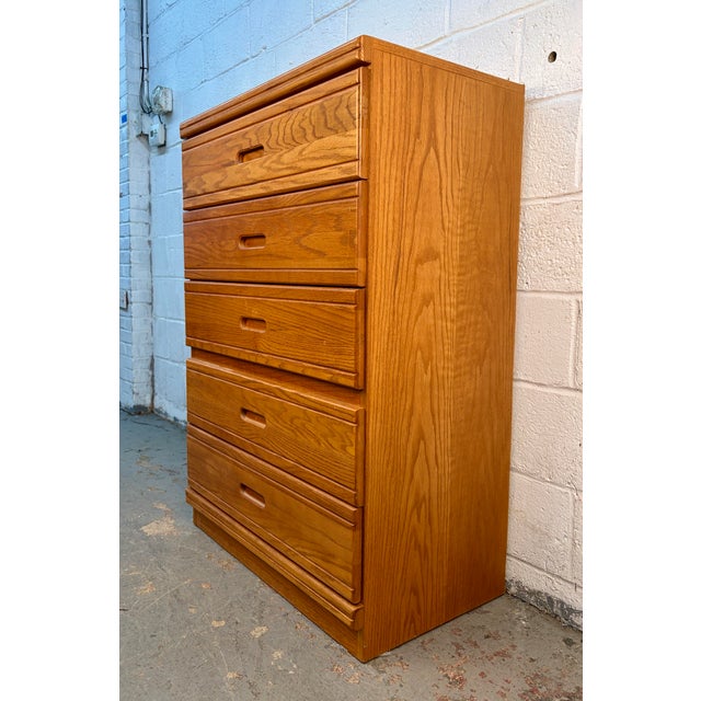 This striking five-drawer tallboy chest exemplifies the clean, sculptural aesthetic of 1980s Post-Modern design. Crafted...