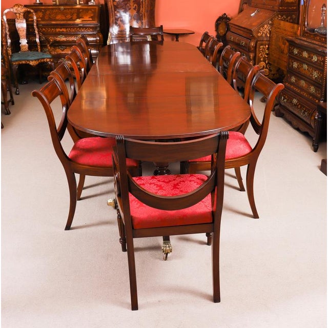 This is an elegant dining set comprising an antique late Victorian three pillar Regency Revival flame mahogany dining...