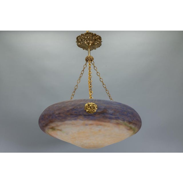 French Art Nouveau pâte de verre pendant, circa 1920. Sculptural pendant light featuring a pâte de verre glass bowl with a...