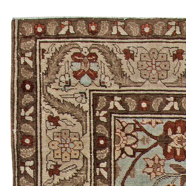 This early 20th century antique Persian Tabriz rug features a striking all-over design of vinery and floral motifs in...