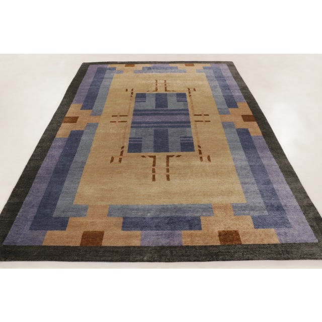 This handwoven wool 7x10 Art Deco rug features a bold geometric design in ivory, lavender, charcoal, and warm brown. Clean...