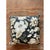 This vintage square cushion is dressed in a bold, large-scale botanical print on a deep, inky black ground. The design is...