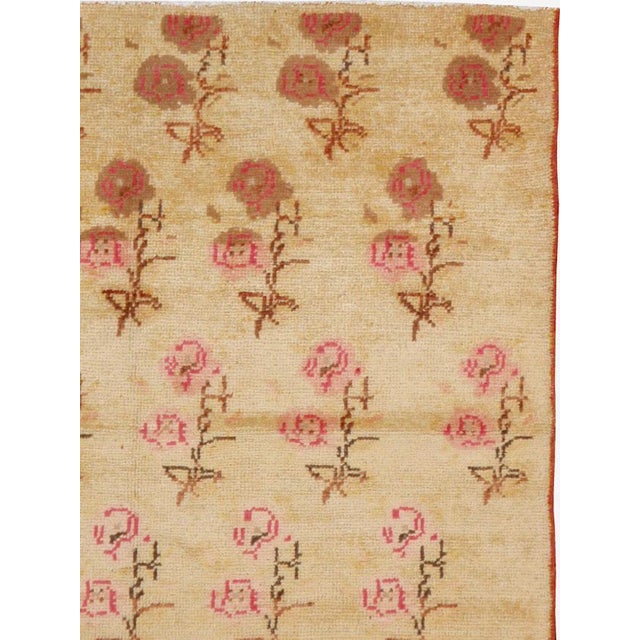 This mid-20th-century Turkish Anatolian rug presents a delicate allover arrangement of stylized rose sprigs across a warm...