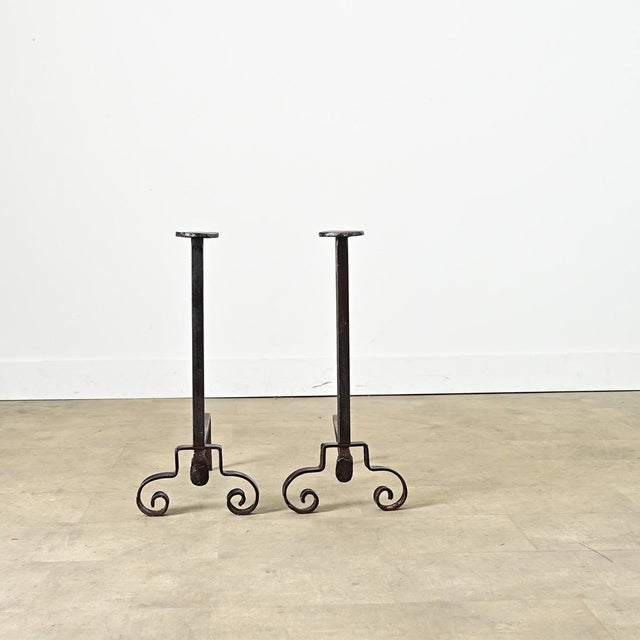 A whimsical pair of French 19th century hand-forged, wrought iron fireplace andirons. Somewhat Gothic in style, the hefty...