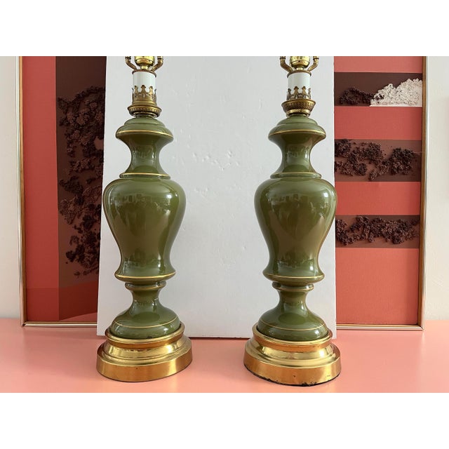Huge pair of 1960s Neoclassical style cased glass column lamps in saturated mossy green accented by gold rings and crown-...