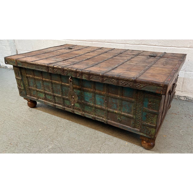 This antique Indian Pitara chest, crafted from teakwood and iron, features distressed turquoise paint and a timeworn...