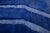 A deep royal blue field traced with pale, meandering ivory lines — abstract markings that feel almost calligraphic against...