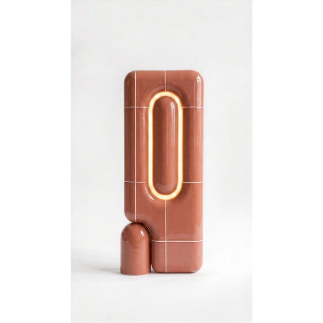 The vertical one. Where the rest of the collection sits low and grounded, this table lamp rises in a slim column of curved...