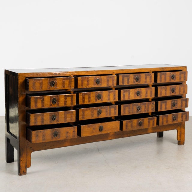 19th century Chinese apothecary console, crafted in elm with sixteen functional drawers and a hand-buffed lacquered...