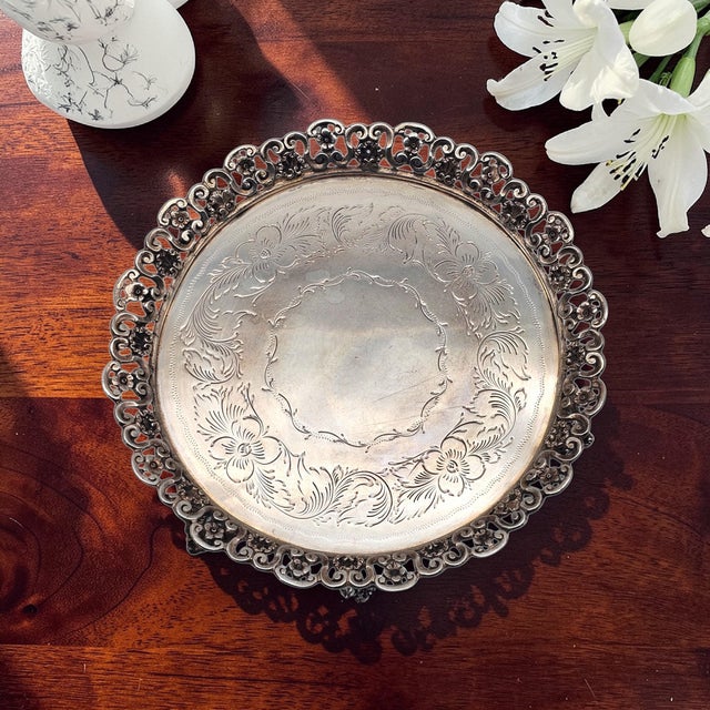 Distinguished by its architectural pierced gallery and substantial weight, this Brazilian alpaca silverplate tray reflects...