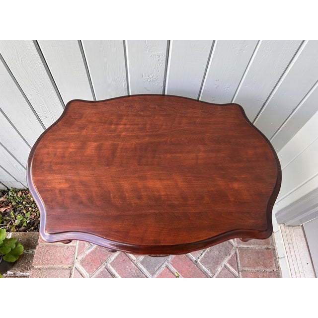 Beautiful vintage pair of lyre-base side tables with carved floral details and gracefully shaped tops. The solid wood tops...