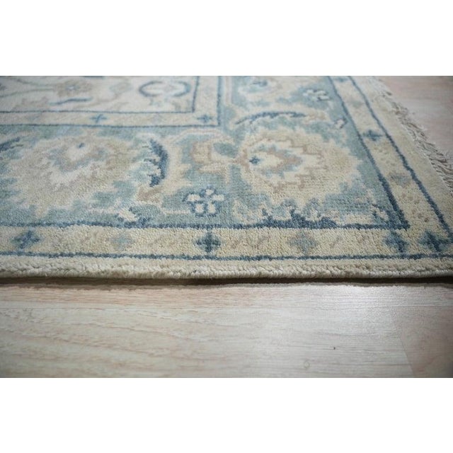 This hand knotted pile rug features a classic traditional design rendered in a soft palette of ivory, beige, cream, and...