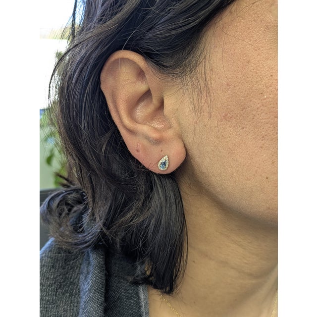 Elegant 14K solid gold earrings featuring shimmering 5×3 mm pear-cut aquamarines accented by natural, earth-mined...