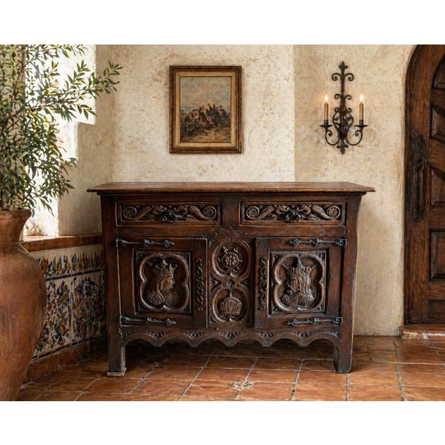 A striking antique carved oak sideboard, likely French Renaissance Revival, dating to the late 19th or early 20th century....