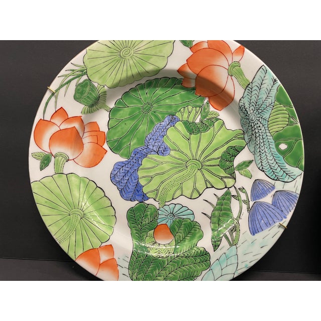 Pair of 1980s Chinese style plates with lotus blossoms and other flora. Unmarked, still have hangers attached.