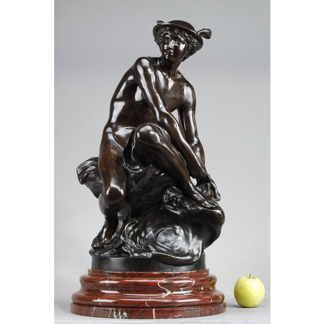 Brown patina bronze sculpture depicting Mercury (Hermes), god of commerce, thieves and messenger of the gods, seated on a...