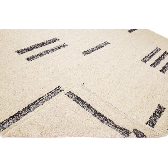 Beautiful modern Moroccan style hand-knotted wool rug with a beige field. This piece has brown accent color in a gorgeous...