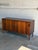 This sleek horizontal storage unit features a minimal profile elevated on tapered legs. Sliding doors reveal adjustable...