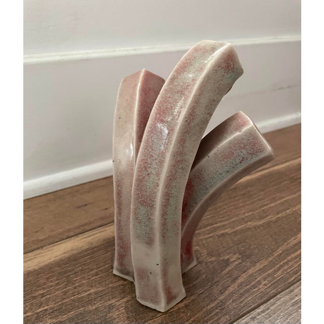 Vintage hand-thrown ceramic vase that blurs the line between function and sculpture, this vase features three organically...