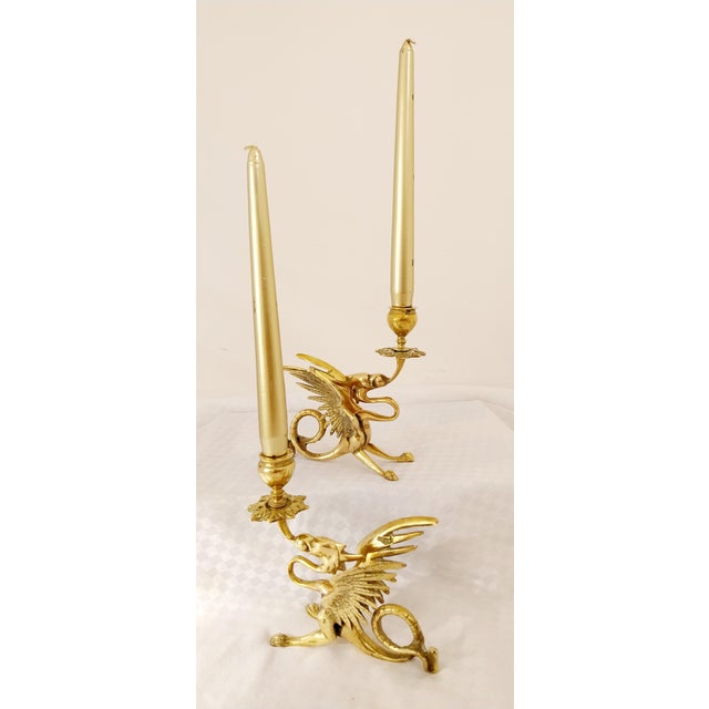 This is a brass candlestick par in the shape of a dragon or griffin. It depicts a mythological creature, probably a dragon...
