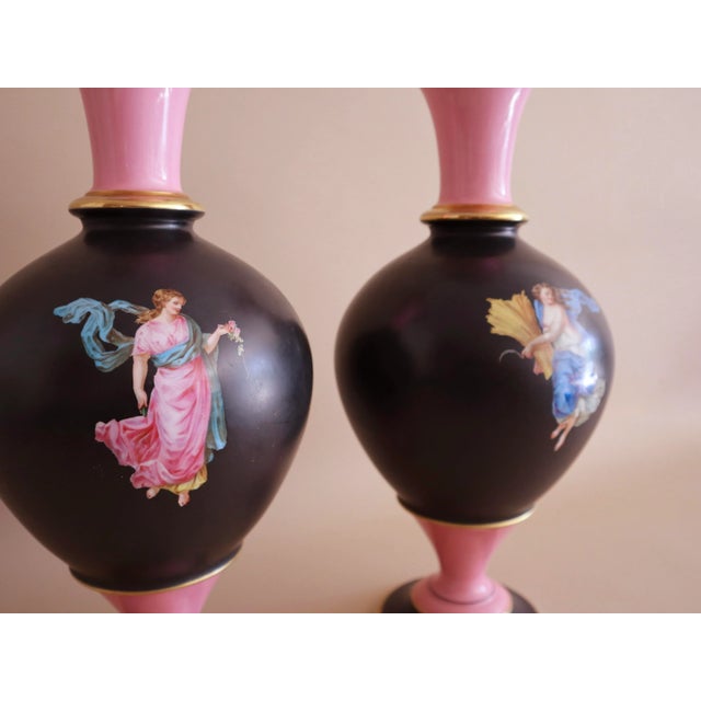 Antique European Sèvres Porcelain Vases, A Pair. Tall black and pink painted vases with gilt gold along the opening/rim...