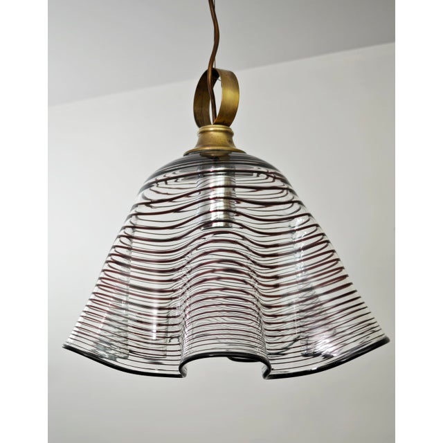 Vintage Murano glass pendant lamp dating back to the 1970s. This chandelier stands out for its craftsmanship, featuring an...