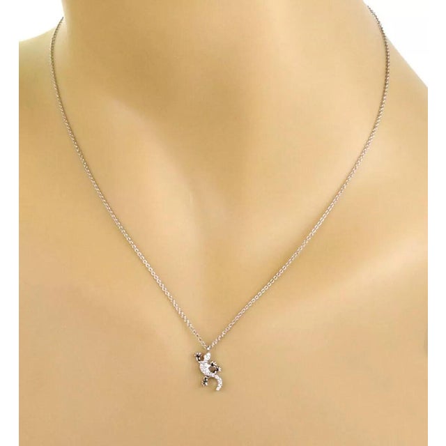 This is a charming authentic pendant and chain necklace from Tiffany & Co. It is crafted from 18k white gold with a high...