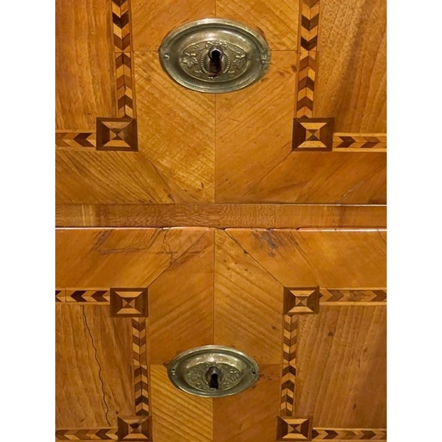 The 19th c. Biedermeier Walnut Inlaid Commode is a beautifully crafted antique piece of furniture from the 19th century....